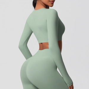 Détail d'un ensemble de yoga vert menthe avec haut court à manches longues et legging haut