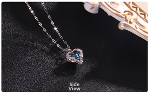 Side view detail of double heart pendant necklace with blue crystal and silver finish