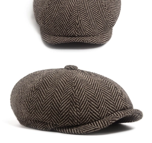 Detailed texture of brown herringbone tweed fabric on a classic vintage newsboy cap