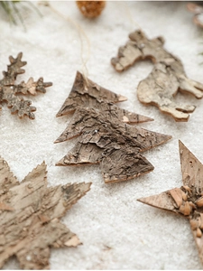 Close-up of natural wood bark Christmas ornaments on a soft white snow background