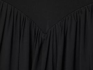 Macro detail of V-shaped seam and pleated black mesh fabric on a stylish maxi dress