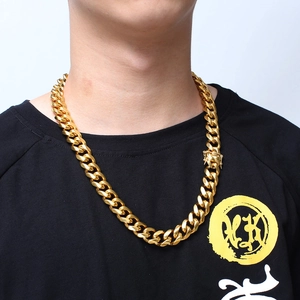 Men's chunky gold Cuban link chain necklace in stainless steel shown on a black T-shirt