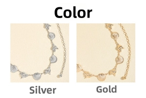 Detail view of gold and silver waist chains with seashell and conch pendant charms