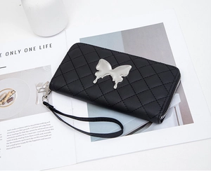 Close-up of black quilted long wallet with silver butterfly hardware and wrist strap