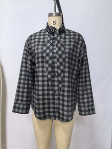 Detailed view of grey plaid long sleeve shirt featuring a front bow tie neck on a mannequin