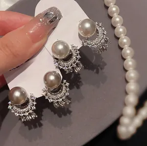 Detail of 925 silver pearl stud earrings with sparkling diamonds and fringe design