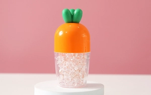 Macro detail of carrot-shaped office push pin container on white podium with pink background