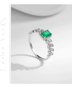 Macro shot of S925 sterling silver ring with emerald-cut green stone and leaf detail