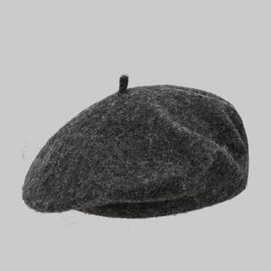 Detailed close-up showing the dark grey wool texture and top button of the beret hat