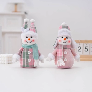 Close-up of plush Christmas snowmen dolls with cozy pink and green fabric outfits