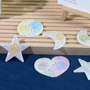 Makroaufnahme von 12 Tierkreis-Harzanhängern in Pastellfarben mit Glitzer für DIY-Schmuck
