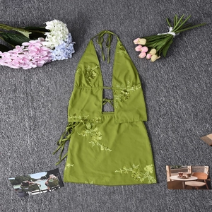 Detailed close-up of green halter neck top and floral embroidery on the mini skirt
