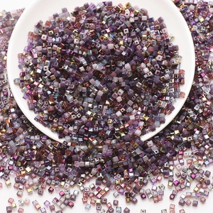 Assorted purple glass square beads in a white bowl for DIY jewelry and crafts making