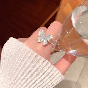 Close-up of a sparkling blue butterfly ring with diamonds on a silver band