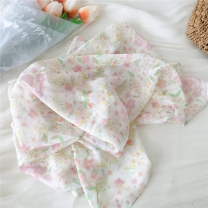 Detail of lightweight sheer floral chiffon scarf with purple flower pattern and soft texture