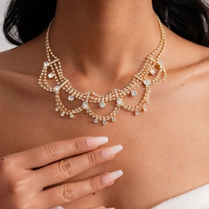 Detailed close-up of a luxurious tiered gold-plated necklace with sparkling tassels