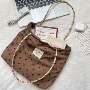 Brown corduroy tote bag detail with colorful beaded strap and sweet heart prints