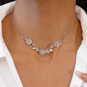 Détail du collier fleur et feuille en argent porté par un mannequin avec pétales élégants