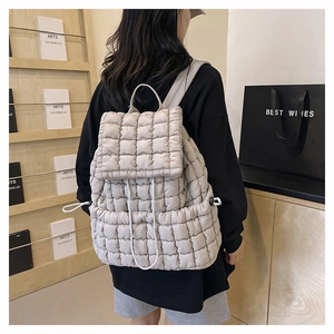 Zaino trapuntato con coulisse mostrato su modella in un ambiente interno minimalista