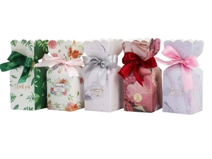 Detail of assorted wedding candy boxes with floral patterns and satin ribbon bows