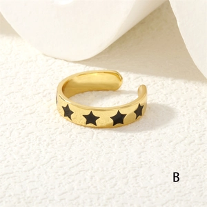 Detailed close-up of a gold adjustable ring featuring elegant black star patterns