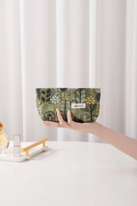 Close-up of green cotton linen cosmetic bag with exquisite floral embroidery and tag