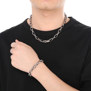 Detail of silver square Cuban link necklace and bracelet set on male model