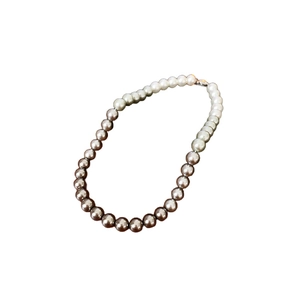 Elegant gradient pearl necklace featuring white to dark grey round pearls on white background