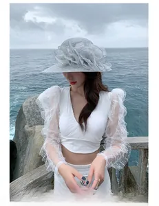 Detailed view of grey wide brim beach hat with elegant 3D floral accent and woven texture