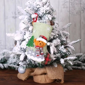 Detail of green linen Christmas stocking featuring 3D bear and snowflake patterns