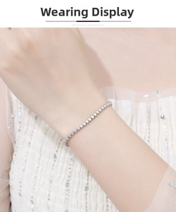 Close-up of 2mm moissanite tennis bracelet in sterling silver worn on a woman's wrist