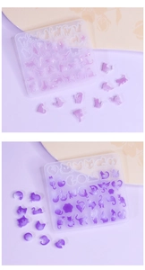 Macro detail of silicone cat earring molds with purple resin samples on textured fabric