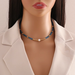 Bohemian seed bead necklace with deep blue beads and white pearl pendant on a model