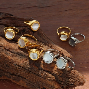 Gold and silver vintage rings with white mother-of-pearl inlay on rustic wood base