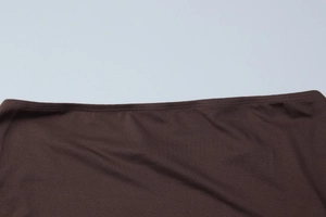 Close-up of dark brown knitted fabric showing professional double-stitch sewing detail