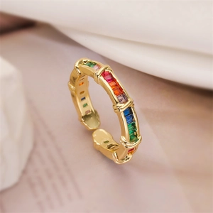 Close-up of golden adjustable ring featuring colorful zircon stones and bamboo texture