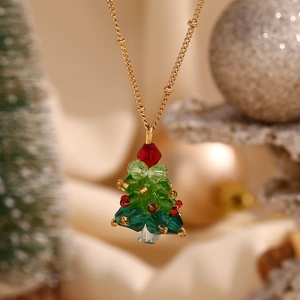 Macro shot of 18K gold plated Christmas tree necklace with green and red crystal beads