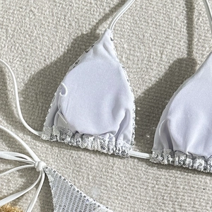 Close-up of white bikini top with detailed silver sequins and halter neck ties