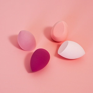 Set of four teardrop makeup sponges in various pink tones on a clean pastel background