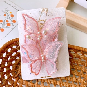 Dettaglio di fermagli per capelli a farfalla in rete rosa con paillettes e perle