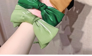 Detailed shot of large satin bow headbands in green and brown with glossy silk texture