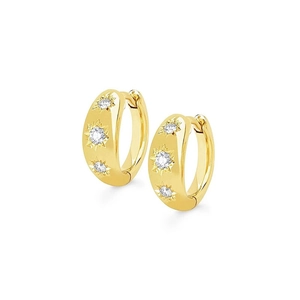 Detail of gold huggie hoop earrings with star-set white stones on white background