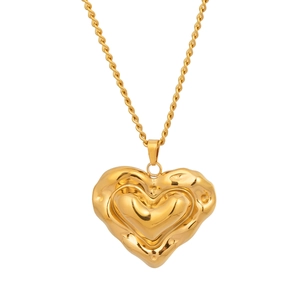 Détail du pendentif cœur doré à texture lave sur un collier chaîne torsadée