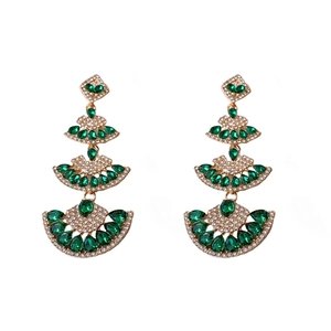 Elegant gold chandelier earrings with green crystals and sparkling diamonds on white backdrop