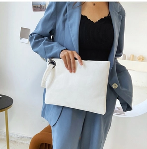 Dettaglio della pochette bianca con trama a scacchi, manico in metallo e finitura PU