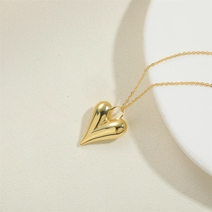 Vue détaillée du collier pendentif cœur en plaqué or 14K poli sur un support blanc