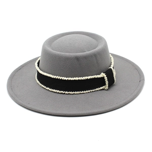 Detail of grey wool felt boater hat featuring elegant black ribbon and pearl bead trim