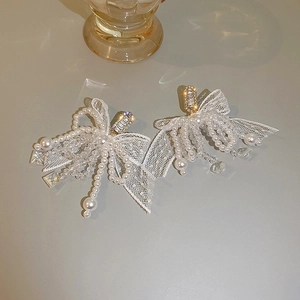 Detail of lace bow earrings with pearls and crystals in a hanging tassel design