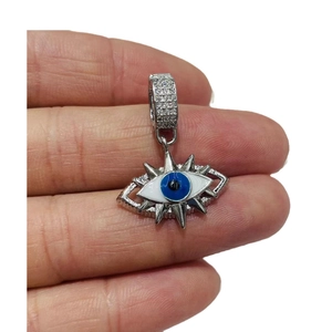 Ciondolo malocchio in argento con centro blu e zirconi tenuto tra le dita