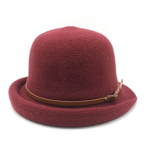 Détail d'un chapeau cloche en tricot rouge foncé avec ceinture en cuir et bordure roulée